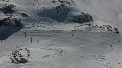 Vista-Aérea-Vertical-Volando-Sobre-Un-Grupo-De-Esquiadores-En-Los-Alpes-Franceses.-La-Plagne